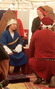 Master Bernard Sterling of Darton presenting the Shires taxes to the Crown as Kinggiyadai Khagan makes a string of puns on the matter. Photo by THL Ceara Shionnach, January 2015.